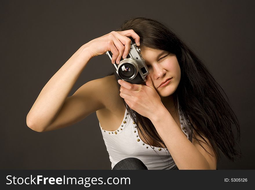 Fashion girl posing with camera isolated on black background. Fashion girl posing with camera isolated on black background