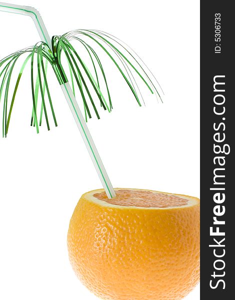 Chopped orange with green decorated drinking straw on white background.