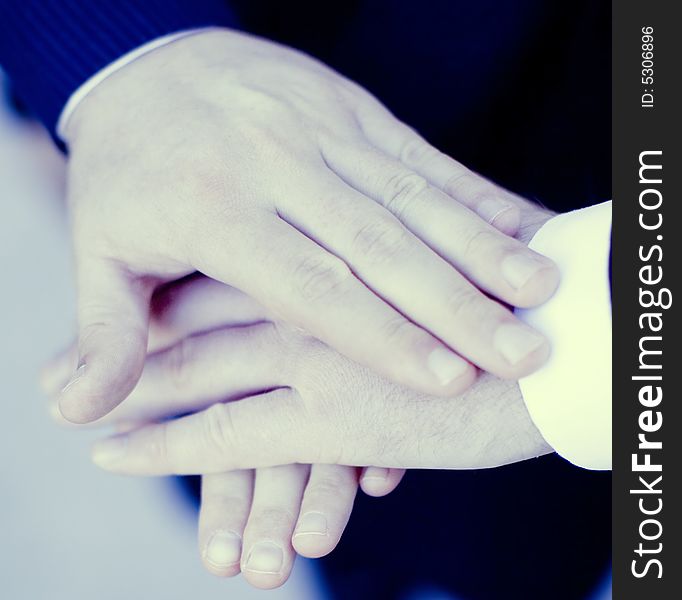 Close up of three hands of businesspeople on top of each other. Close up of three hands of businesspeople on top of each other