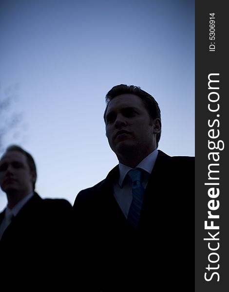 Silhouette of businessmen standing against blue sky background