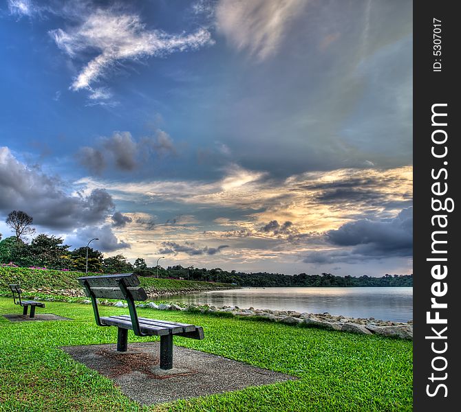 Empty Park Benches during Sunset over a reservoir. Empty Park Benches during Sunset over a reservoir