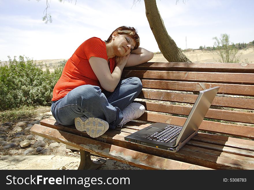 A young woman using a portable computer outside. A young woman using a portable computer outside