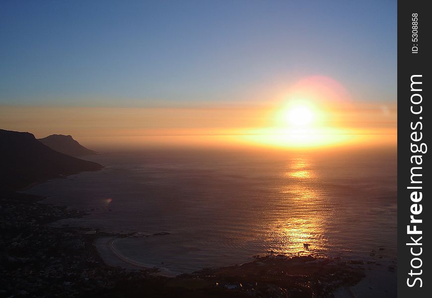 The sunsetting over clifton beach lighting up the ocean. The sunsetting over clifton beach lighting up the ocean.