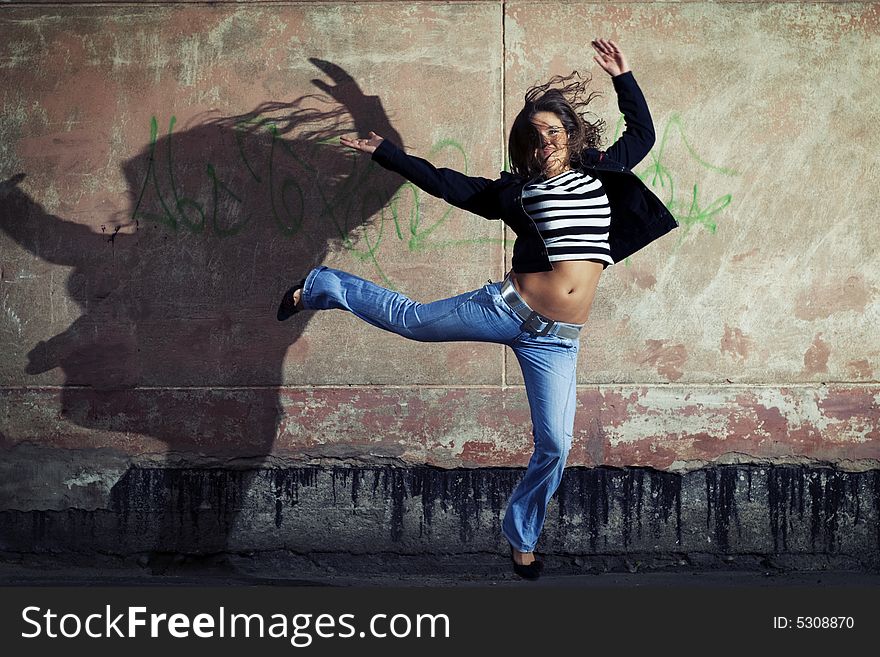 Young cute girl jumping against the wall. Young cute girl jumping against the wall.