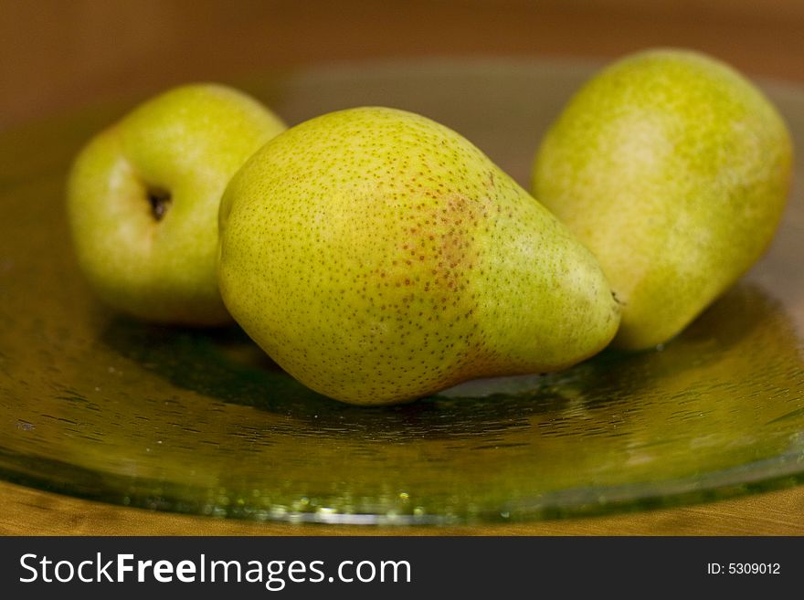 Tree fresh pears on a green plate. Tree fresh pears on a green plate