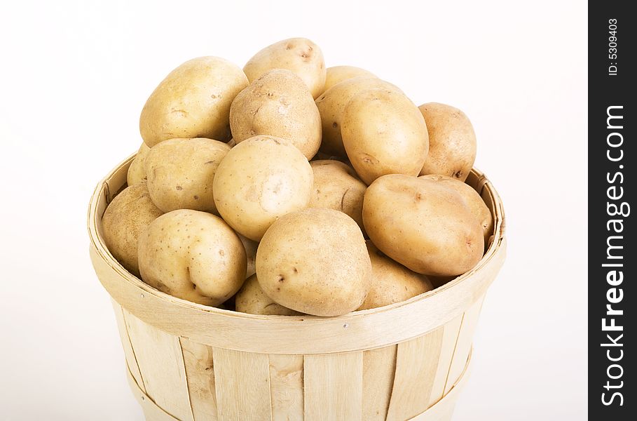 Potatoes in a woven basket on a white backround. Potatoes in a woven basket on a white backround