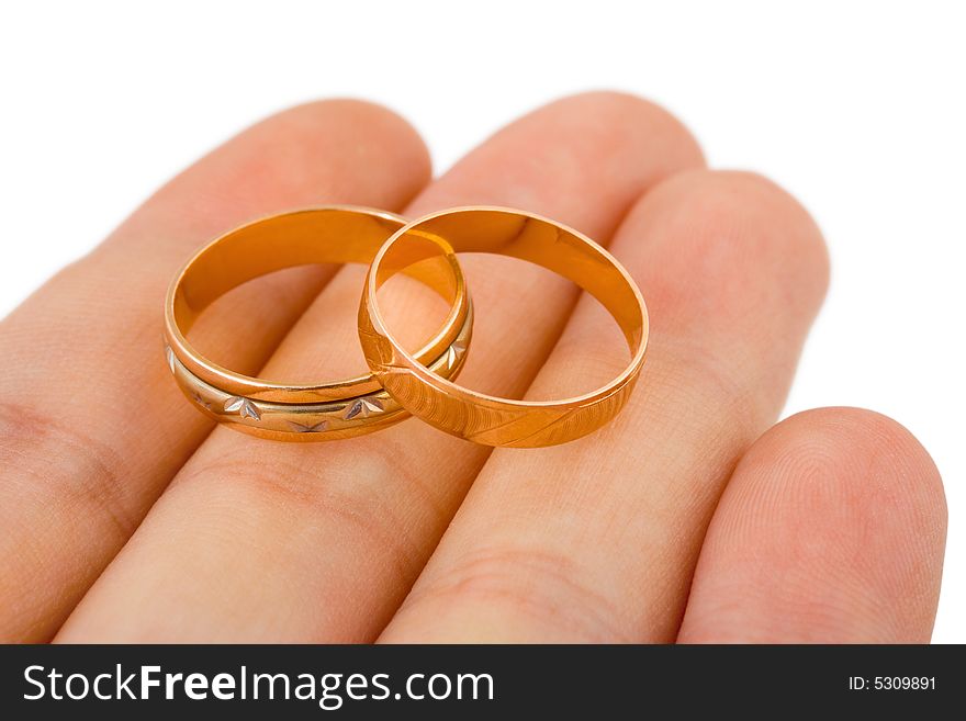 Wedding gold rings on hand isolated on white background