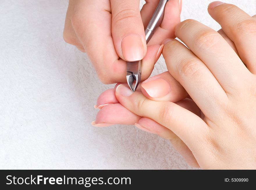 Nail salon - cuticle cut on the female little finger