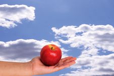 Apple In Palm With Sky Background Stock Photos