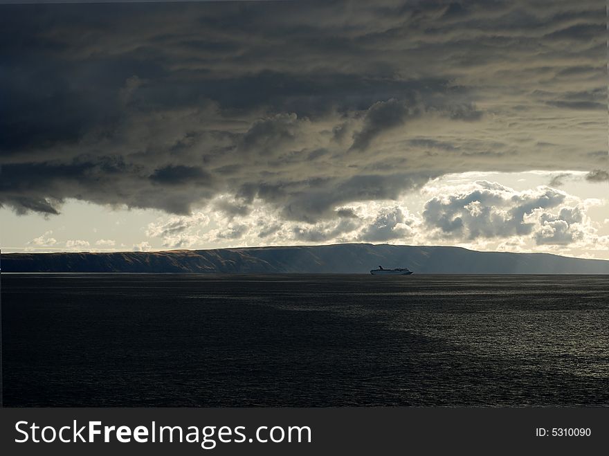 Storm clouds gather over a ship at sea. Storm clouds gather over a ship at sea.