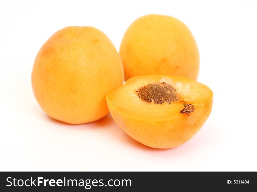 Two Apricots with halves on white background