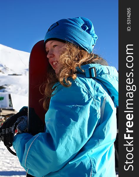 The young girl has a rest in mountains and goes for a drive on a snowboard. The young girl has a rest in mountains and goes for a drive on a snowboard