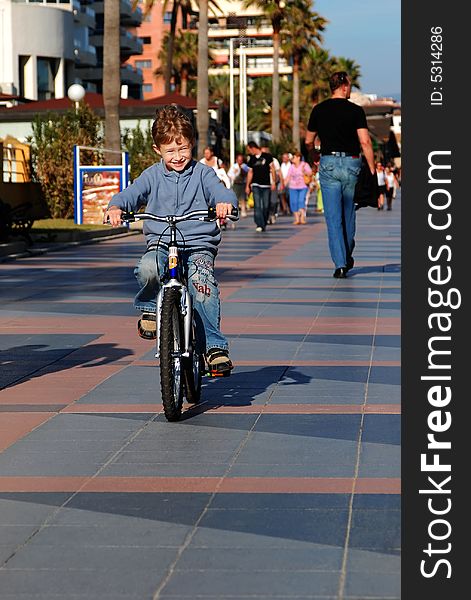 The happy boy goes for a drive on a bicycle