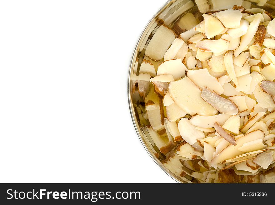 Shiny Stainless Steal Bowl of Sliced Almonds on White. Shiny Stainless Steal Bowl of Sliced Almonds on White