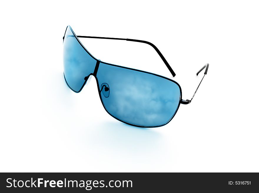 Sunglasses reflecting blue sky and clouds