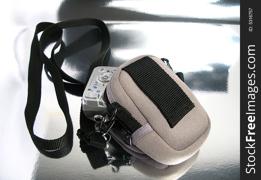 Digital camera in their case in a silver background