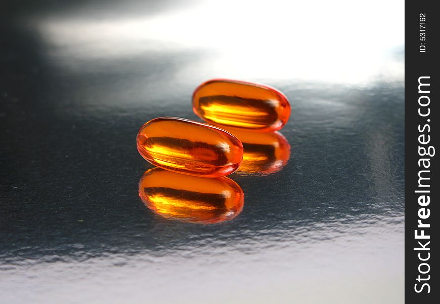 Gelatin capsules in a silver background