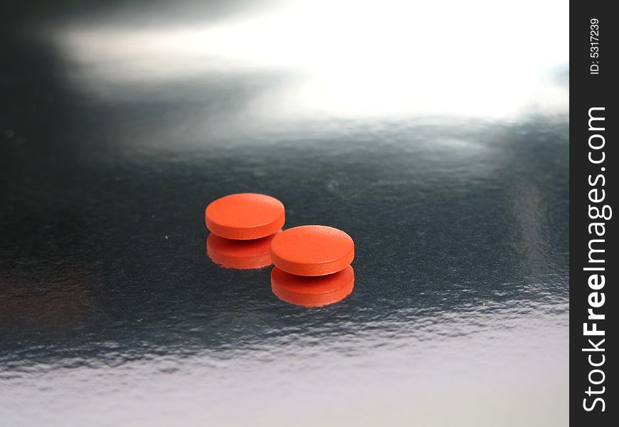 Orange medicines in a silver background