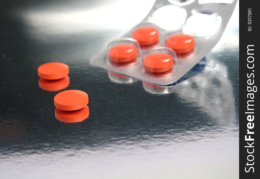 Packed orange medicines in a silver background