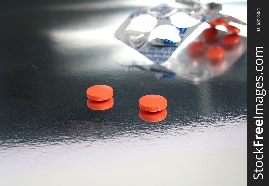 Packed orange medicines in a silver background