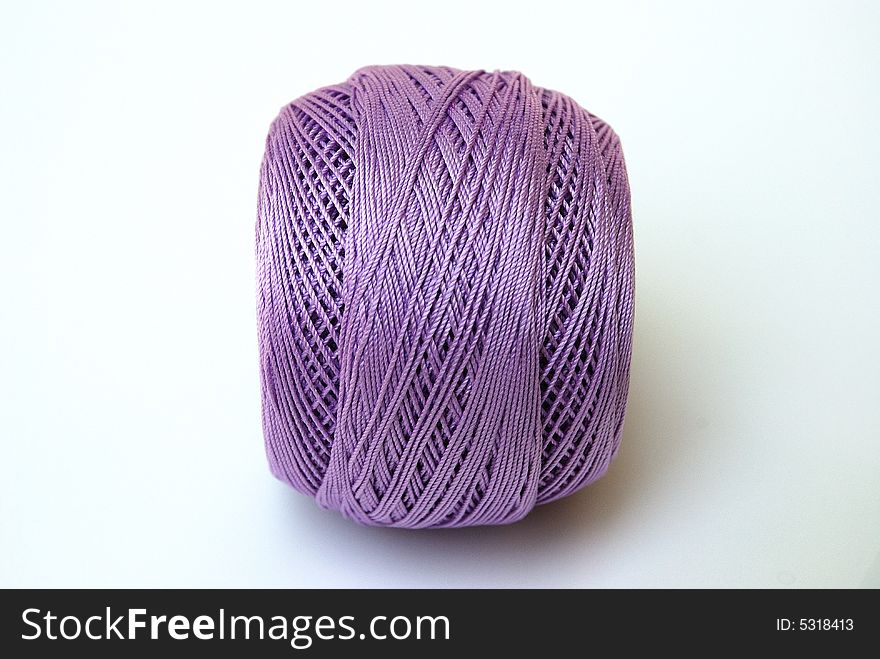 Close up lilac yarn ball for handicraft projects like crochet and knitting.