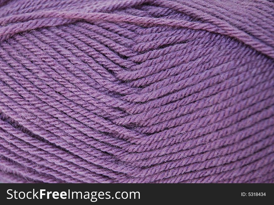 Close up lilac yarn ball for handicraft projects like crochet and knitting. Close up lilac yarn ball for handicraft projects like crochet and knitting.