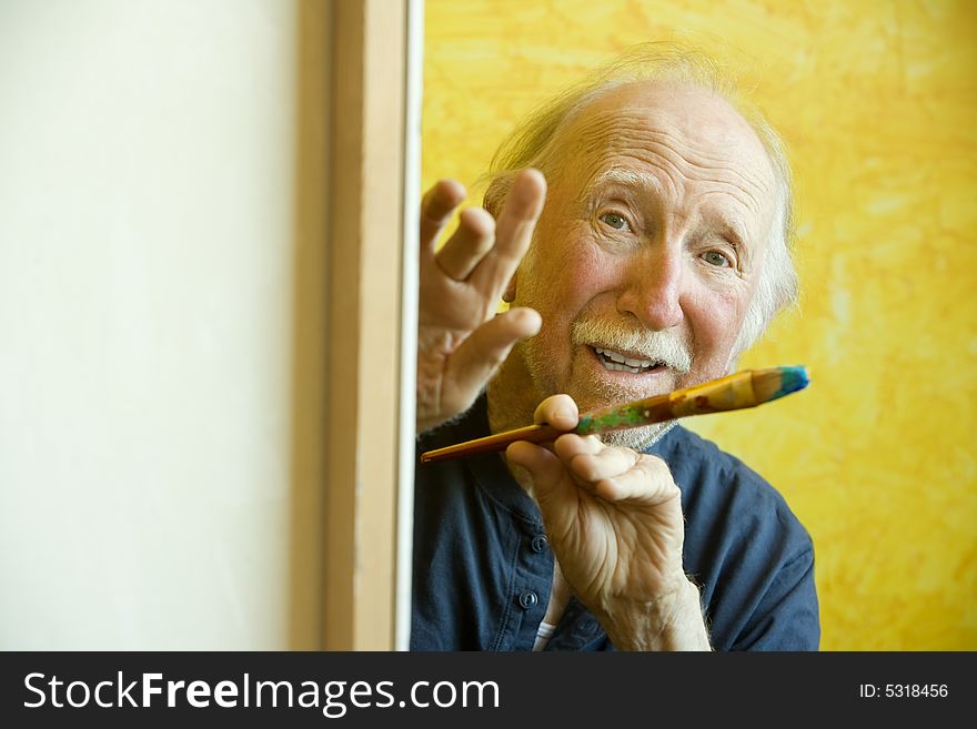 Elderly painter working on a large canvas. Elderly painter working on a large canvas