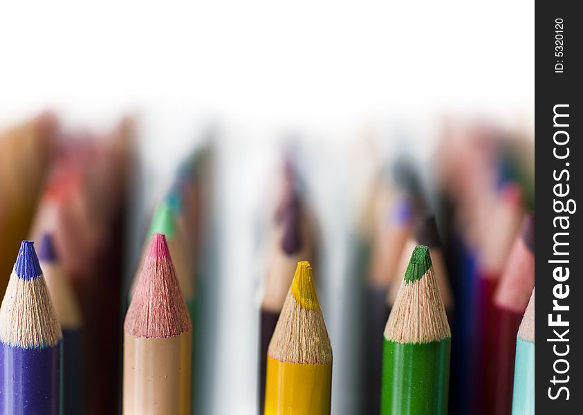 Rows of Bright colored pencils against white background