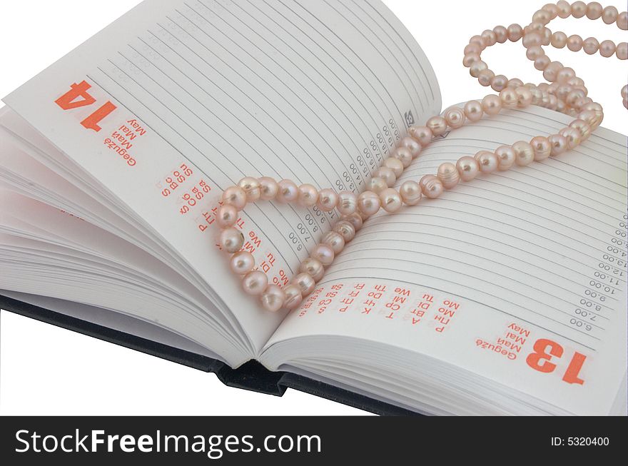 Open diary and pearl beads as a bookmark. Open diary and pearl beads as a bookmark