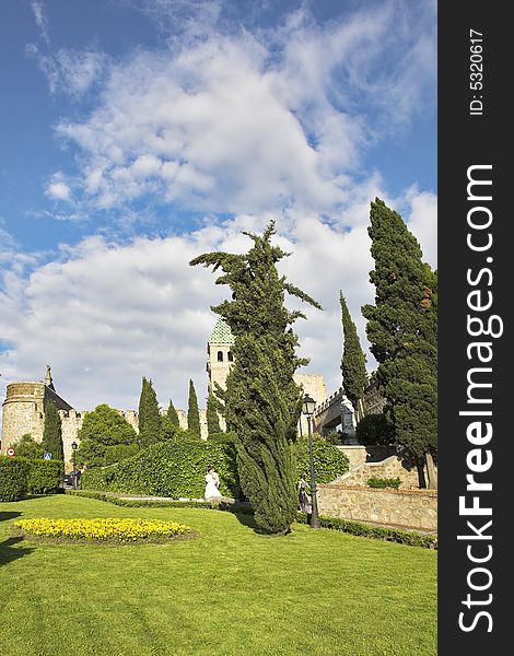 Grassy lawns and flower beds at walls of ancient city Toledo