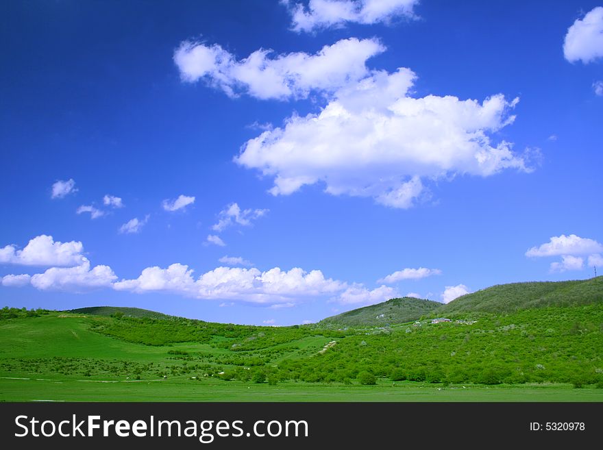 Green field and hills with blue sky and clouds. Green field and hills with blue sky and clouds