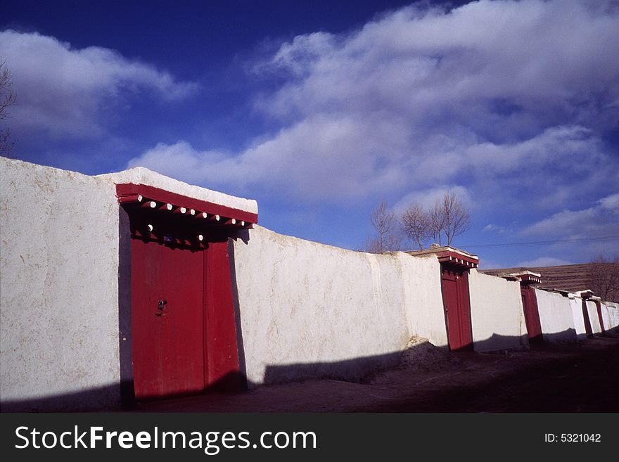 Houses of the monks in a lama temple, sichuan, china. lamas like to brush their walls white and the doors red. Houses of the monks in a lama temple, sichuan, china. lamas like to brush their walls white and the doors red.
