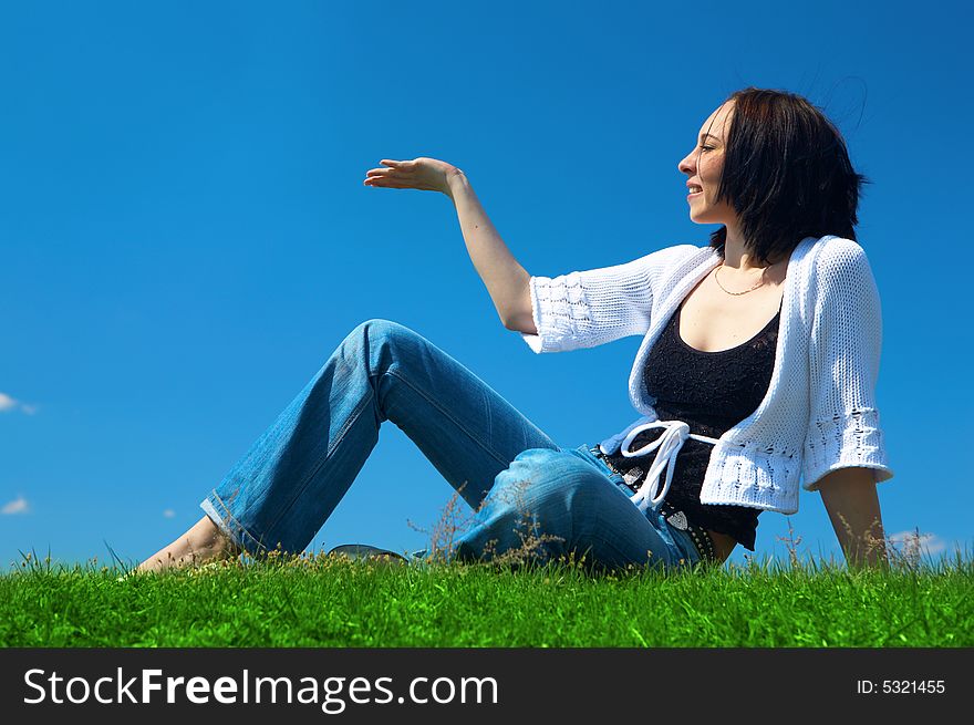Woman sit in green field un hold hand palm up