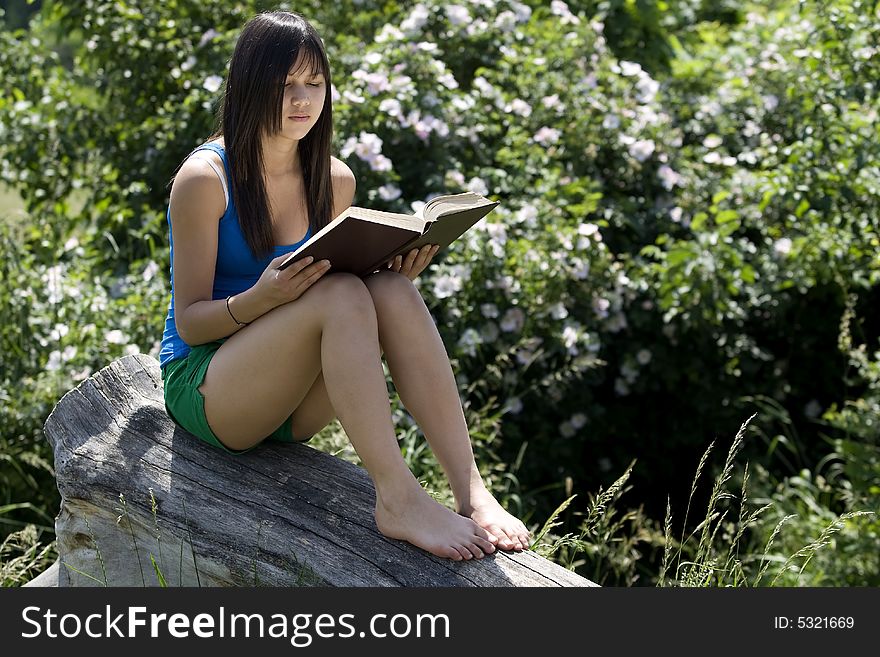 Teenager read a book in nature at an excursion