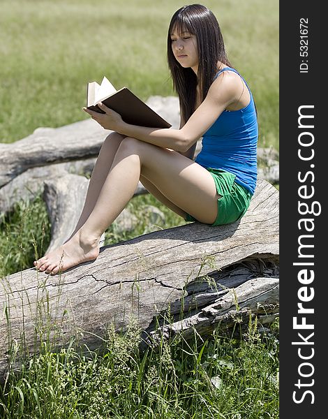 Teenager read a book in nature at an excursion