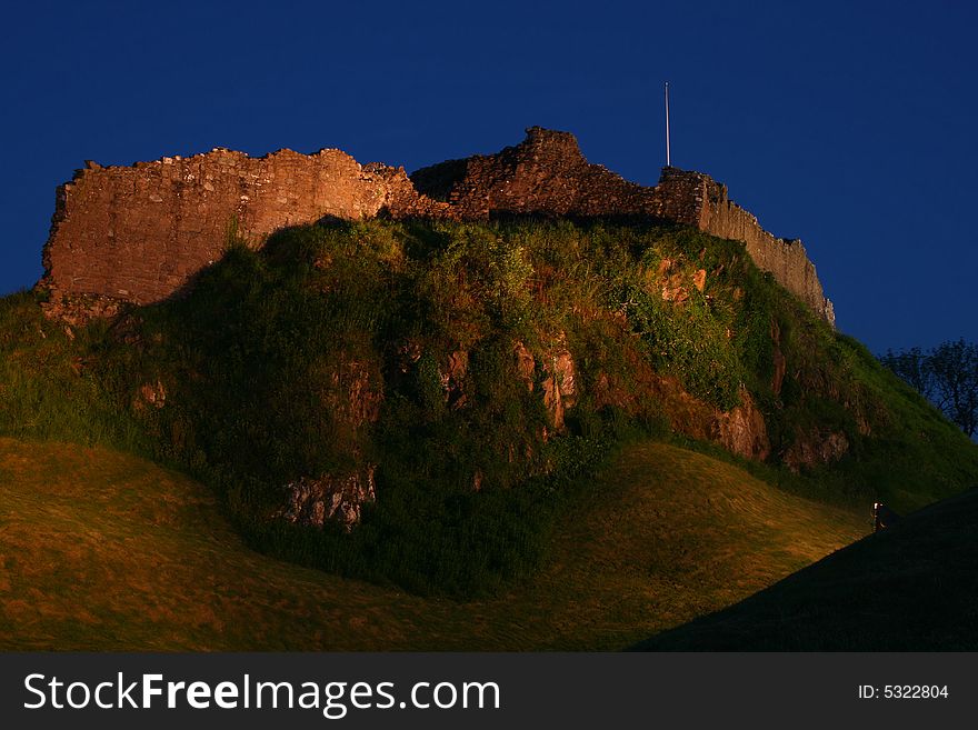 The ruins of the castle at Urquhart at night near Inverness on the banks of Loch Ness in Scotland. The ruins of the castle at Urquhart at night near Inverness on the banks of Loch Ness in Scotland