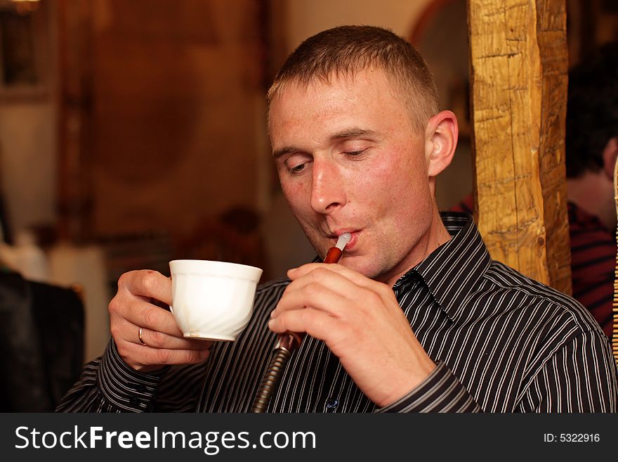 The smoking man with cup of coffee. The smoking man with cup of coffee