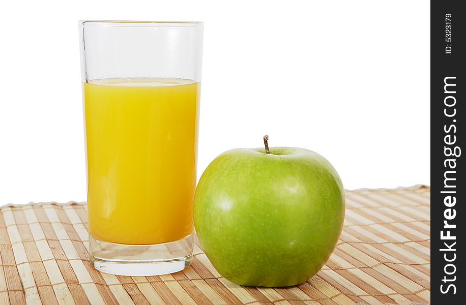 The glass of orange juice and green apple