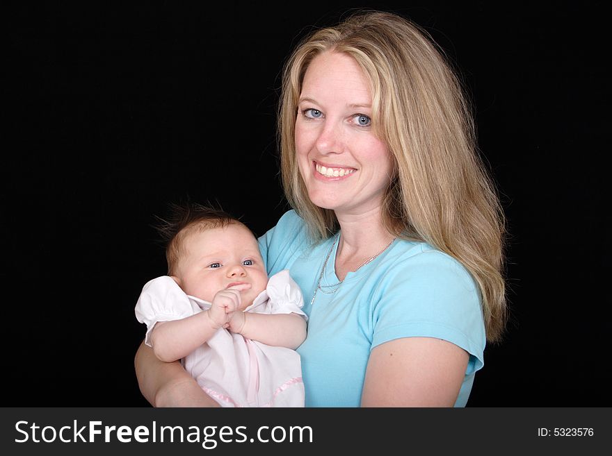 A new mother smiles while holding her new daughter. A new mother smiles while holding her new daughter.