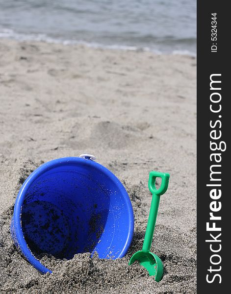 Blue Bucket on beach sand in northwest washington water