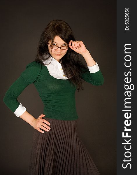 Serious looking girl in glasses isolated on black