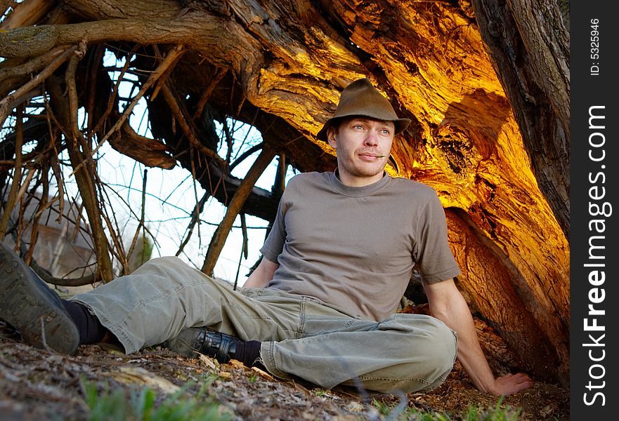 The man lays under an old tree