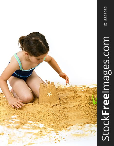 Girl playing in the sand isolated on white