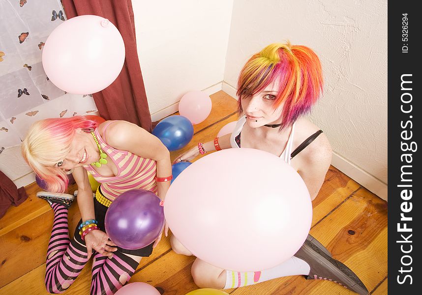 Two punk girls in a room with colorful balloons. Two punk girls in a room with colorful balloons