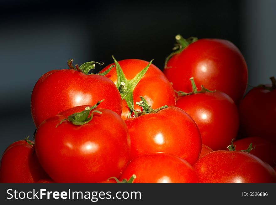 Group pf fresh ripe tomatoes on dark background, selective focus