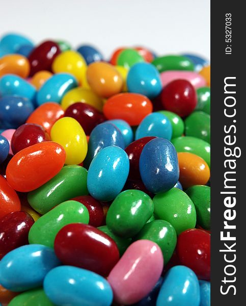 Multiple colored jelly beans on a light background.