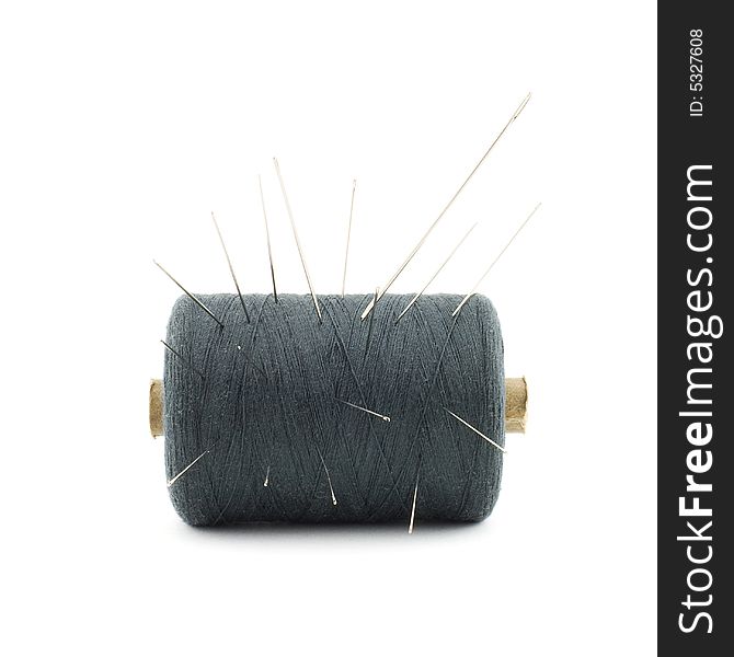 Isolated photo of reel of threads with needles