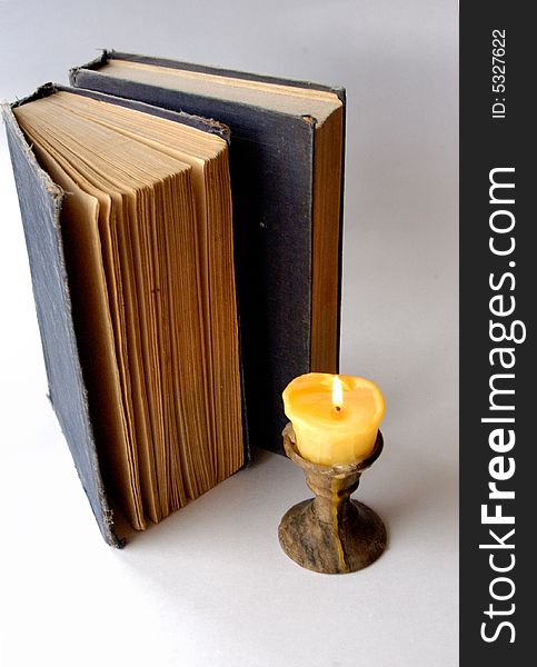 Old books with light candle. Old books with light candle