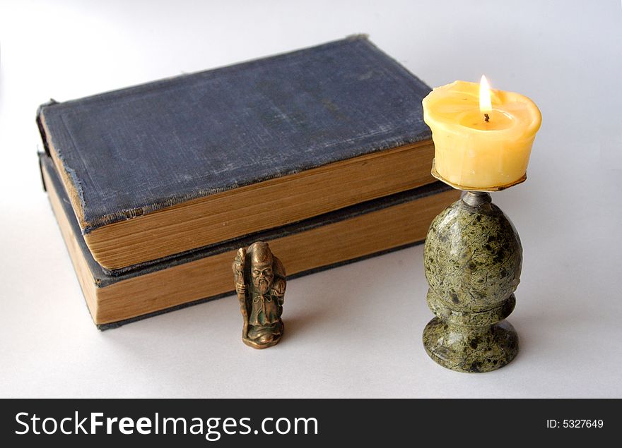 Old books with monk and candle