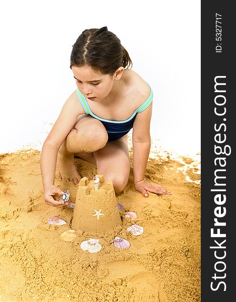 Girl playing in the sand isolated on white
